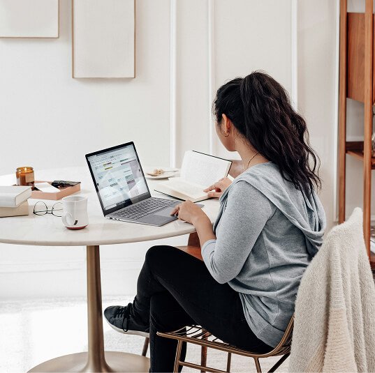 Woman-working Woman working on her laptop facing away from the camera.