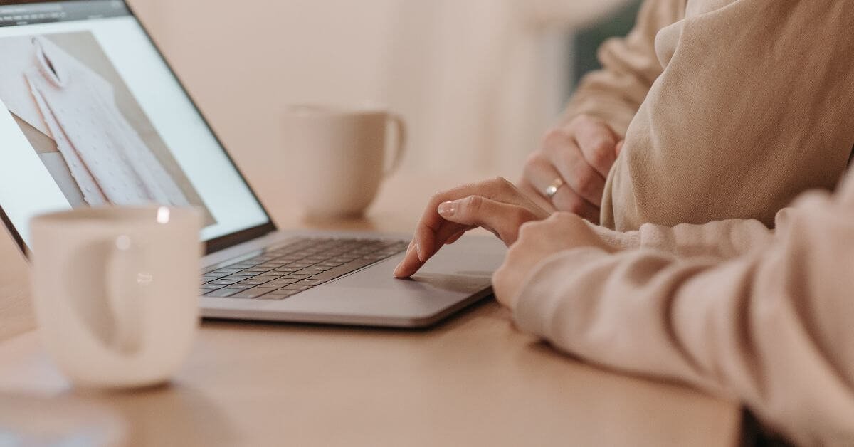 Woman working on her laptop, gaining clarity in business by strategizing and planning her next steps.